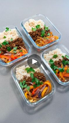 four plastic containers filled with food sitting on top of a gray table next to each other