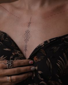 a woman with tattoos on her chest and hand holding the other side of her body