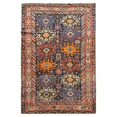 an antique persian rug with multicolored geometric designs and fringes on the edges