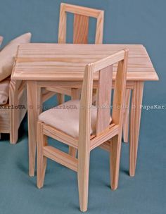 a dollhouse table and chairs made out of wood with cushions on the seat area