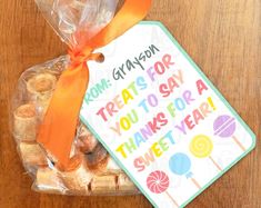 an orange ribbon is tied around a bag of treats that say congratulations to someone who loves sweets