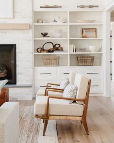 a living room filled with furniture and a fire place next to a white brick wall