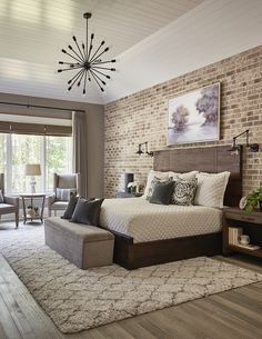 a bedroom with brick walls and furniture in the corner, along with a chandelier