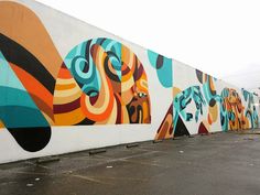 a large mural on the side of a building in an empty parking lot with no people