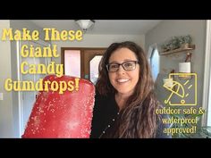 a woman standing in front of a giant red ice cream cone with the words make these giant candy gumdrops?