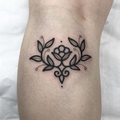 a black and white tattoo design on the side of a woman's leg with leaves