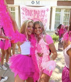 two women in pink outfits posing for a photo