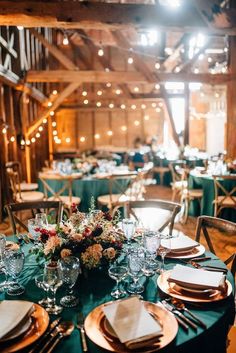 the tables are set for an event with green linens and gold place settings on them