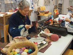 two women are working on crafts in a craft room with baskets and other items sitting on the table