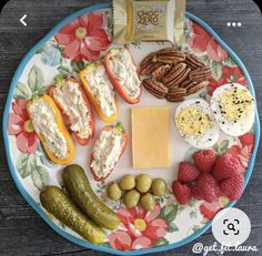 an assortment of food on a plate with nuts, crackers, cheese and fruit