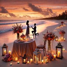 two people sitting at a table with candles and flowers on the beach next to them