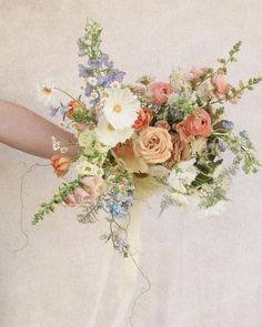 a woman holding a bouquet of flowers in her hand