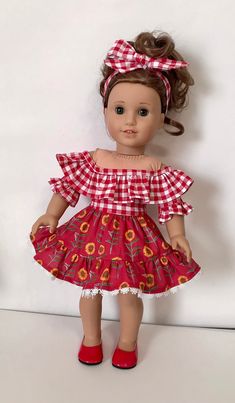 the doll is wearing a red and white dress