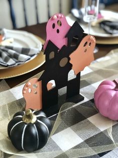 the table is decorated with black and pink paper cutouts, pumpkins, and plates