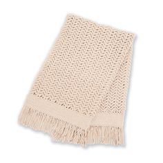 a white knitted blanket with fringes on the bottom and one end in beige