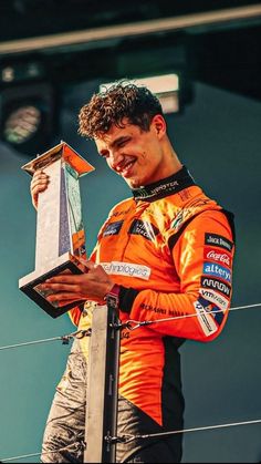 a man standing on top of a race track holding a trophy