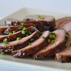 sliced meat with green onions on a plate