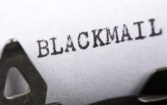 an old typewriter with the word blackmail printed on it's paper, closeup