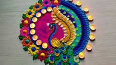 a colorful peacock made out of candles on a table