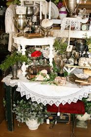 a table covered in lots of different types of dishes and vases on top of it