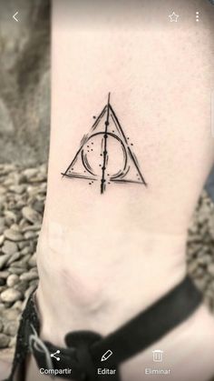 a small tattoo on the foot of a person with a deathly symbol in it