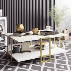 a living room with black and white striped wallpaper, gold accents and a coffee table