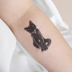 a black cat tattoo on the arm