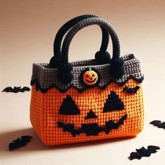 an orange purse with black bats on it and a jack - o'- lantern