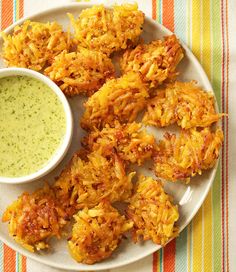 some food is on a white plate with a green dipping sauce