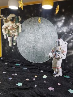 an astronaut standing in front of a mural on the wall next to a child's space suit