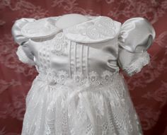 "The Abigail Christening Dress is ready. I have spent many happy hours designing each piece with your baby in mind. The fabrics were chosen for their smooth, comfortable finish. The inside of the garment is expertly finished with French seams and binding to ensure your baby has a calm, irritation free day. Fine hand sewing is found through the garment including on the hand inserted sleeves and hand sewn hems. The Abigail Christening line was inspired by traditional Christening/Baptism gowns using heirloom techniques. The dress includes symbolism to mark the sacred nature of your baby's day. White satin and lace represent the purity we receive through of the Lamb of God. Each sleeve has three pleats as a reminder of the Father, the Son, and the Holy Spirit. The lace trim around the waist po Blessing Dress, Lace Bonnet, Baptism Gown, Christening Gown, Baptism Dress, Christening Dress, Happy Hours, Embroidered Collars, Free Day