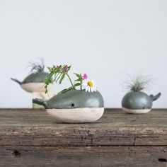 three ceramic whale planters sitting on top of a wooden table