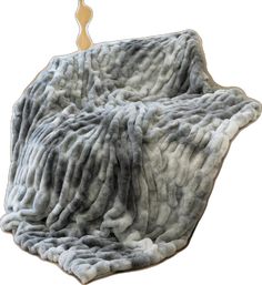 a gray and white blanket sitting on top of a wooden stick