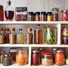 many jars filled with different types of food and spices on shelves in a kitchen or pantry