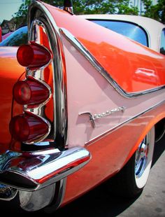 an orange and white car parked in a parking lot