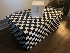 a black and white checkered table sitting on top of a hard wood floor