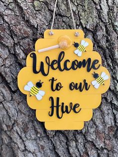 a sign that says welcome to our hives hanging on the side of a tree