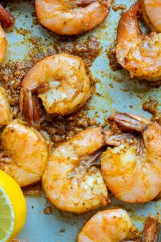 cooked shrimp with lemon and spices on a baking sheet