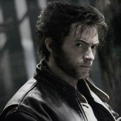 a man in a leather jacket looking at the camera with an intense look on his face