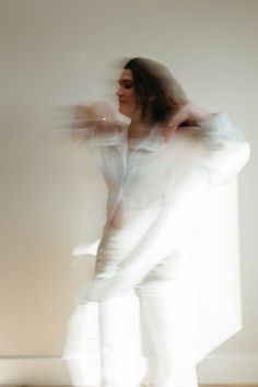 a blurry photo of a woman standing in front of a wall