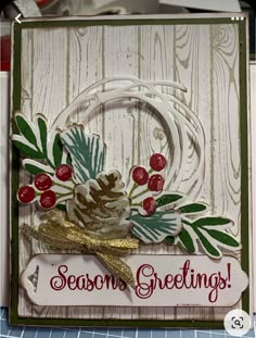 a handmade christmas card with pine cones and berries