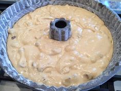 an uncooked cake in a pan sitting on top of a stove burner