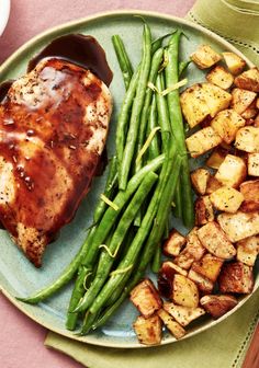 a plate with green beans, potatoes and meat