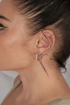 a woman with ear piercings on her left side and the top part of her head