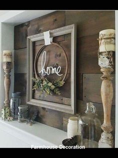 a wooden sign that says home hanging on the wall next to candles and other items