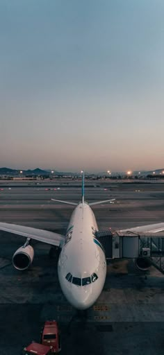 an airplane sitting on the tarmac at dusk