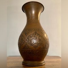 a brown vase sitting on top of a wooden table