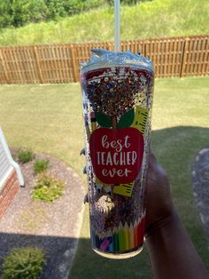 a person holding up a cup filled with confetti and sprinkles