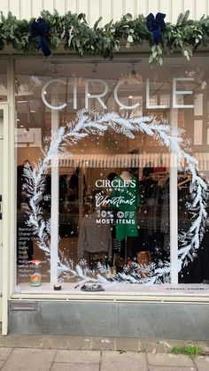 the front window of a clothing store with wreaths on it