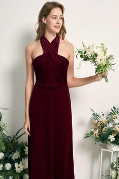 a woman in a long dress holding flowers